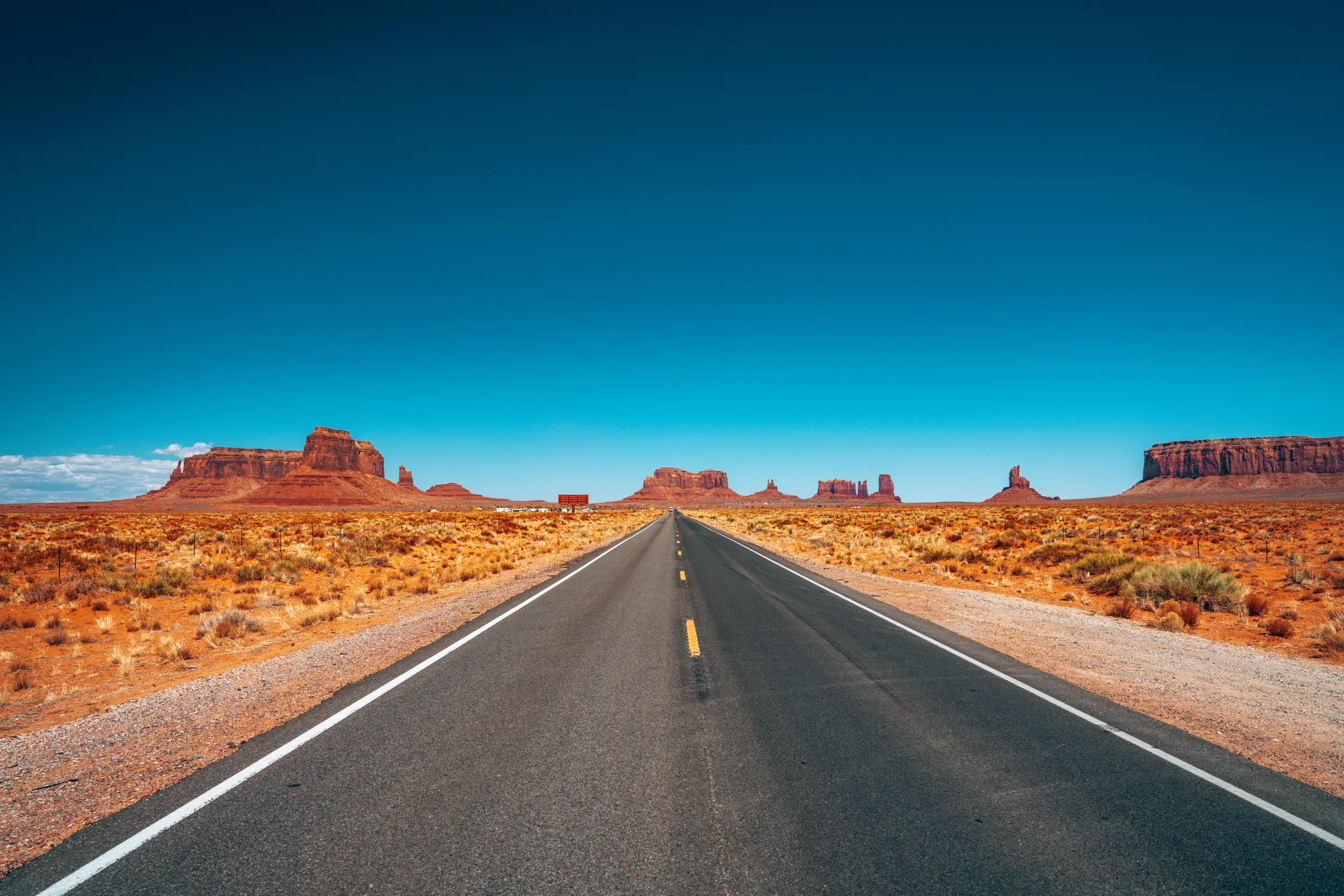 A two-lane American highway running toward open country